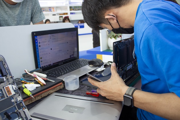 Nhân viên Bảo Hành One đang sửa chữa laptop cho khách hàng