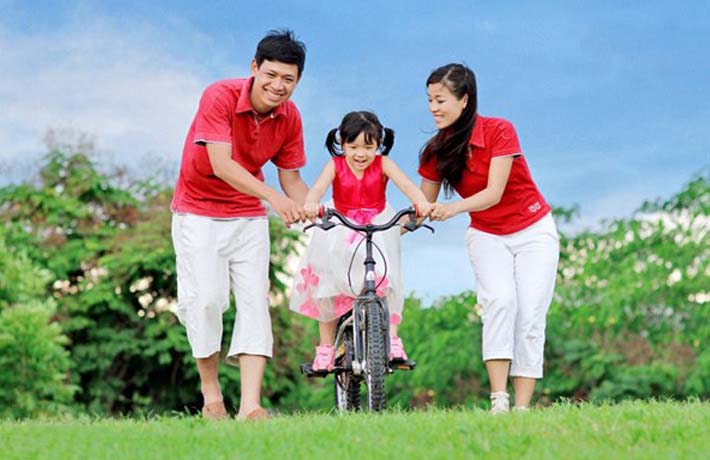 Hình ảnh bố mẹ đang tập xe đạp cho con đầy ấm áp