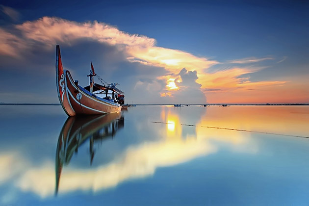 Hình ảnh chiếc thuyền đơn độc trên một hồ nước phẳng lặng
