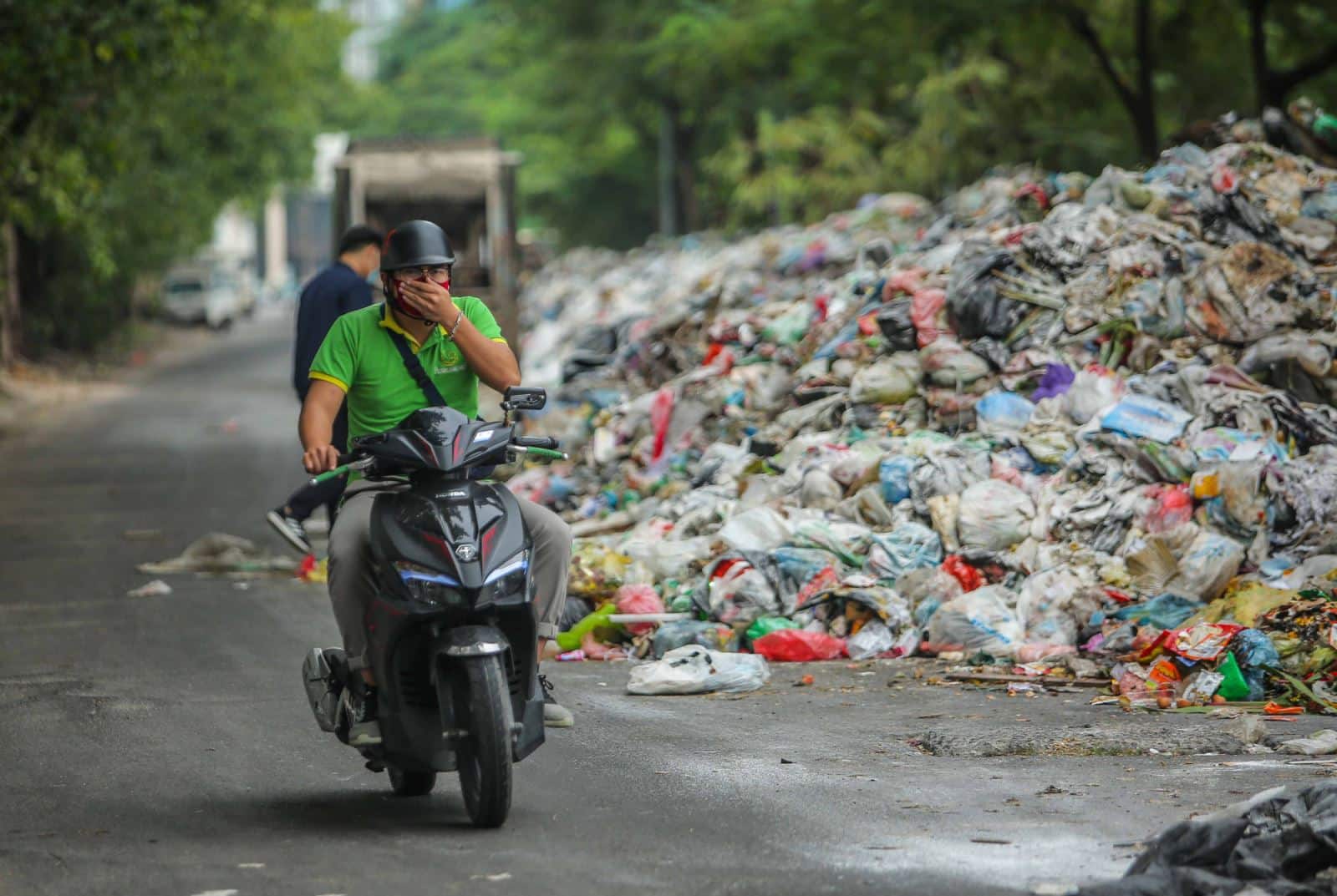 Hình ảnh người dân phải bịt mũi khi đi qua con đường toàn rác thải