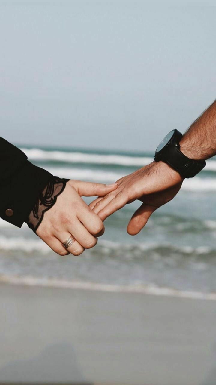 Hình ảnh nắm tay crush trên bãi biển.