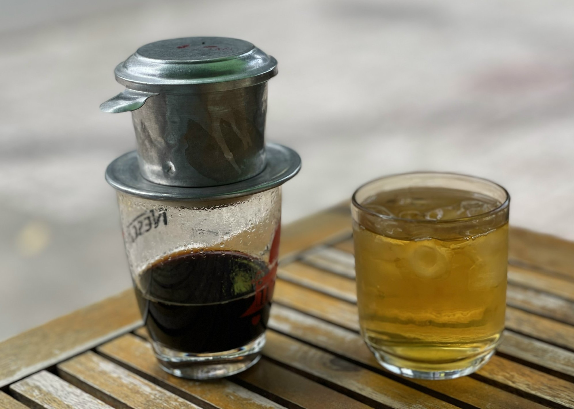 Hình ảnh ly cà phê phin và cốc trà đá vỉa hè.