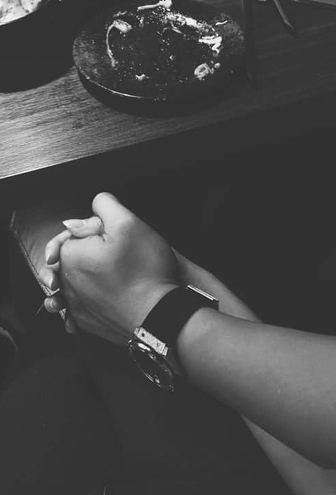 Hình ảnh nắm tay nhau đen trắng trong quán cafe.